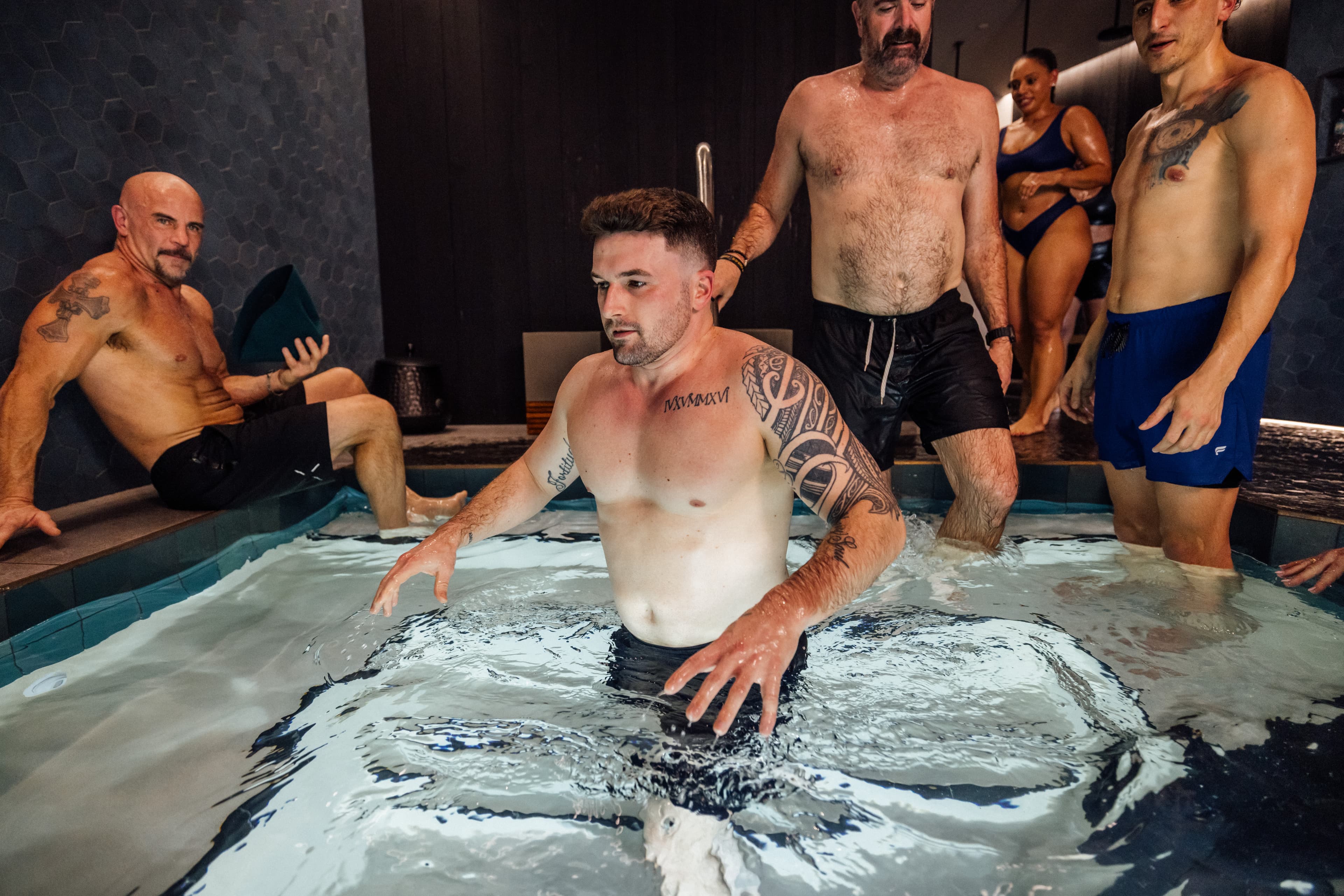 Instructor guiding a participant into the cold plunge